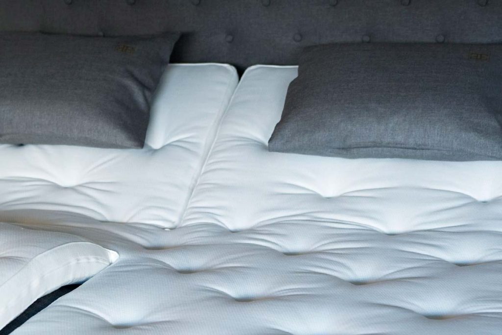 Split mattress topper for an adjustable bed