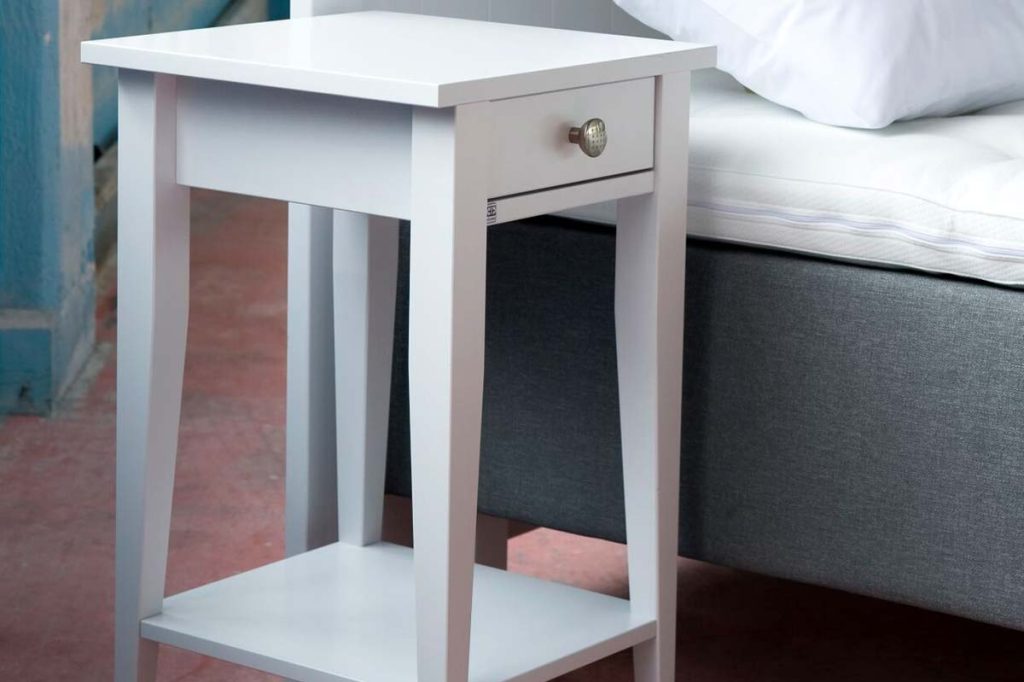 White-lacquered bedside table with a drawer